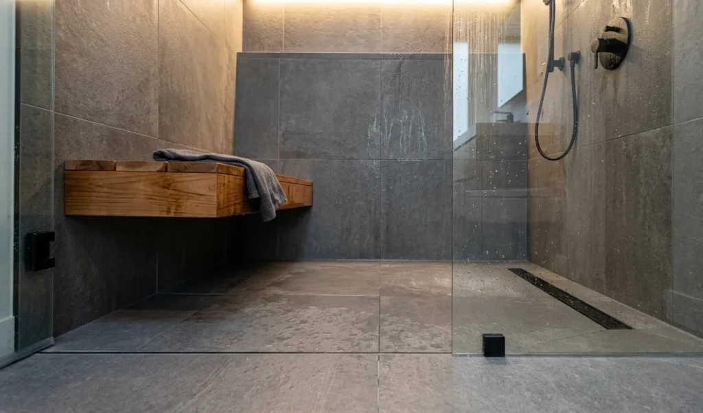 Bath Vs Shower: Costs, Resale Value & Which One Wins In 2026 2 Curbless walk-in shower with rain showerhead and built-in bench